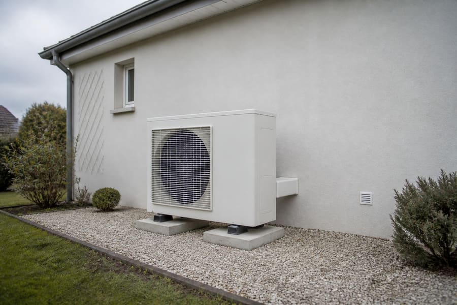 Pompe à chaleur extérieure sur plots béton dans un jardin de l'Aisne